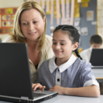Young-School-Girl-on-Laptop-with-Teacher1440