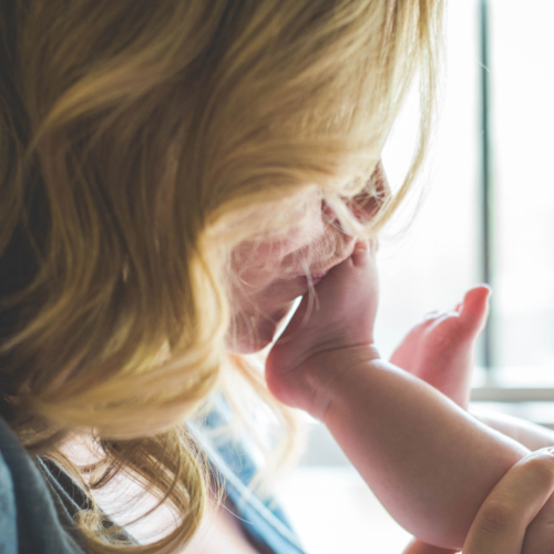 Mum kisses baby's foot.