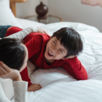 mother-tween-son-on-bed-laughing2160