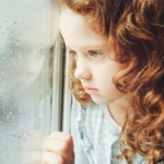portrait-sad-girl-looking-out-window2160