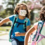 two-girls-running-with-masks-backpacks2160