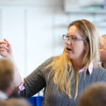 teacher pointing in class with teens