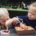 2 kids eating chips and sauce Getty Images