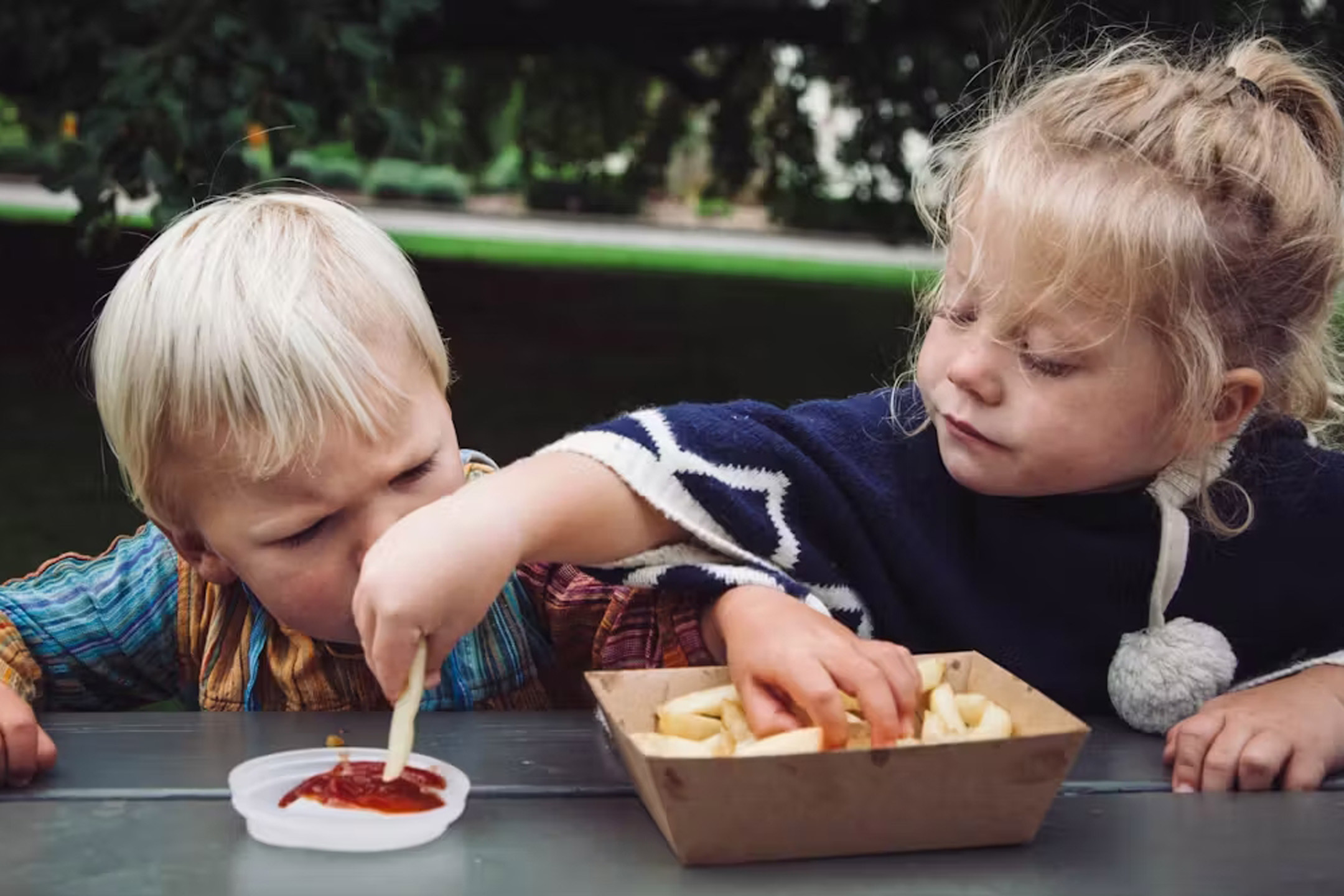 2 kids eating chips and sauce Getty Images